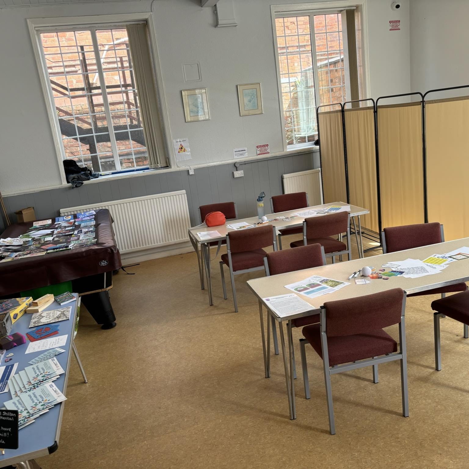 Inside the cafe showing tables and chairs and a screened off one to one area.